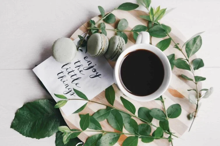 Coffee and green macrons on a plate